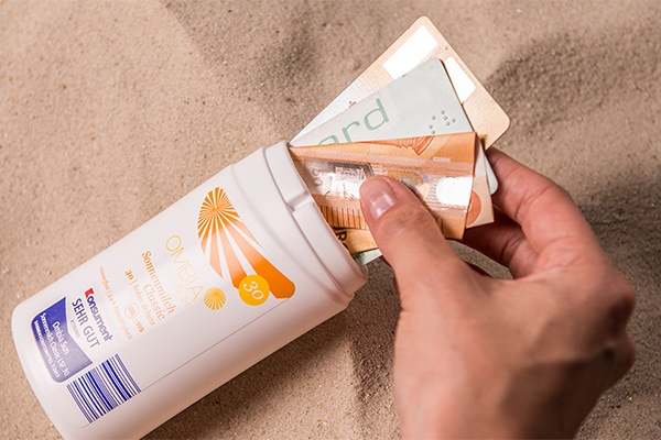 E-Card, Ausweis und Geld in die Verpackung für Sonnenschutz geben und sicher baden gehen