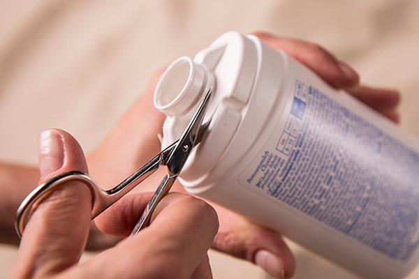 Oberseite der Sonnencreme mit einer Schere ausschneiden