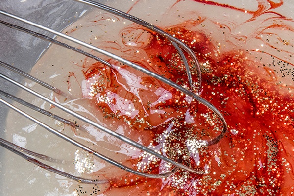 Glitzer, Schleim und Farbe in einer Schüssel verrühren
