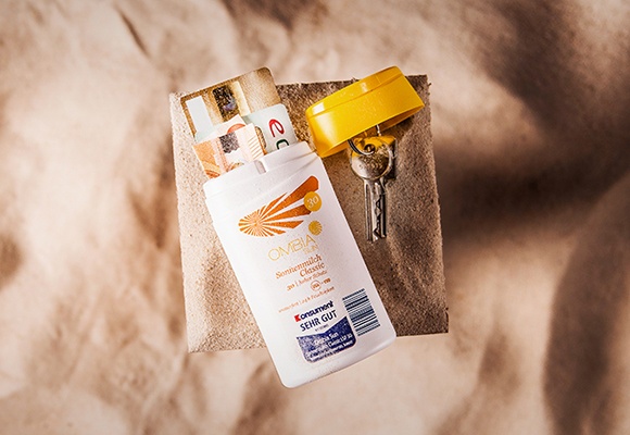 Schlüssel, Geld, Sonnenbrille & Sonnenschutz auf dem Badehandtuch