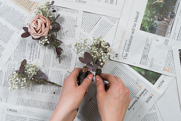 Kleine getrocknete Blumensträußchen werden zusammengebunden.