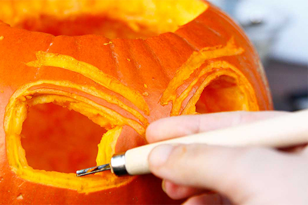 In einen Kürbis werden Augen geschnitzt