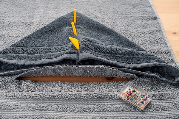 Kapuze mittig auf das Rückenteil legen und mit Nadeln feststecken