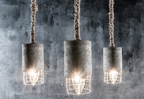 Drei Lampen im modernen Beton Stil hängen von der Decke und erstrahlen den Raum