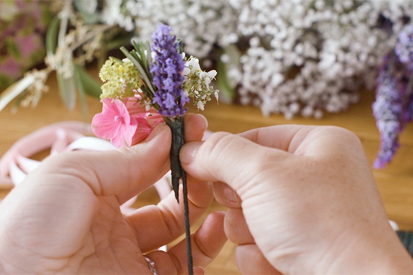Die kleinen Sträußchen mit Blumendraht auf unserem großen Drahtgestell befestigen