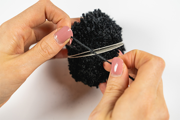 Bei einem Pompom wird ein Knoten gebunden