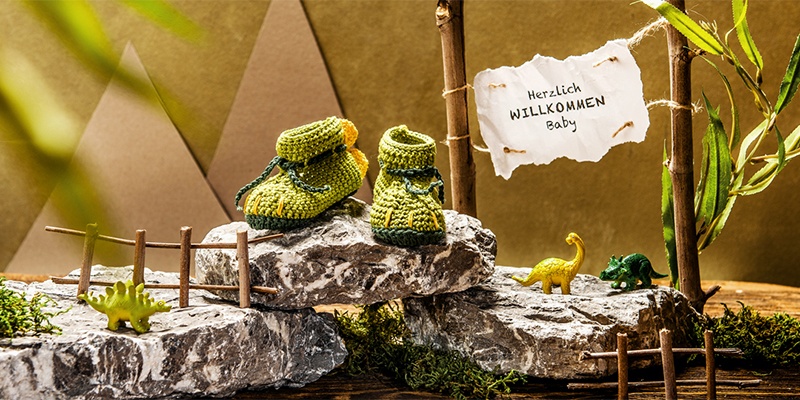 Gestrickte Baby Schuhe auf einem Stein dekoriert.