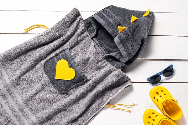 Im Ergebnis ist ein kreatives Badetuch für Kleinkinder entstanden, gelbe Accessoires ergeben ein sommerliches Bild