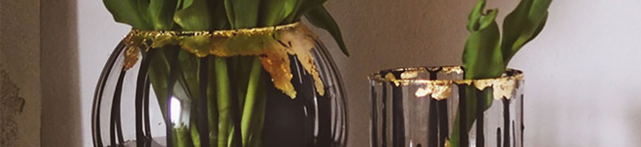 DIY Color Dripping Vasen mit Acrylfarbe und Blattgold, befüllt mit gelben Tulpen als Dekoration auf einem Sideboard mit Lampe