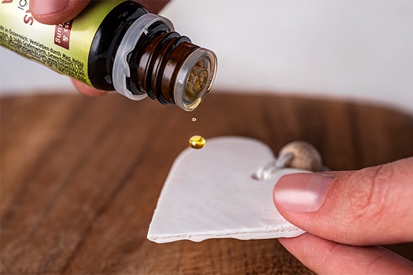 Einen Tropfen ätherisches Öl auf die Rückseite des DIY Duft-Anhängers geben