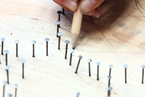 Motiv als Vorlage auf Holz einzeichnen und die Nägel Schritt für Schritt entlang der Linien befestigen