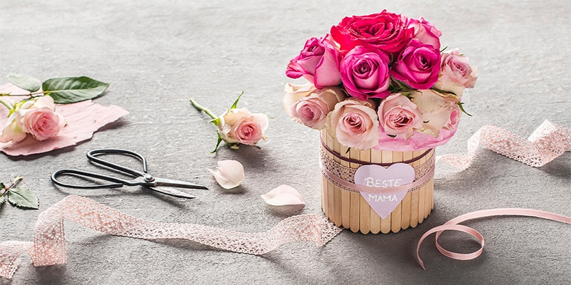 DIY Flower Box mit Deko-Bändern und Rosenblüten als Geschenk zum Muttertag verziert
