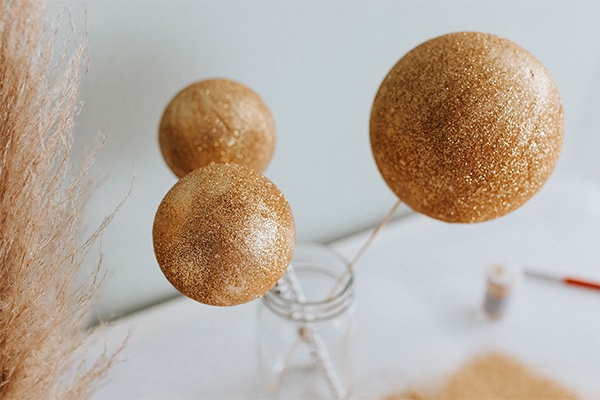 Goldene Glitzer-Kugeln als Partydekoration