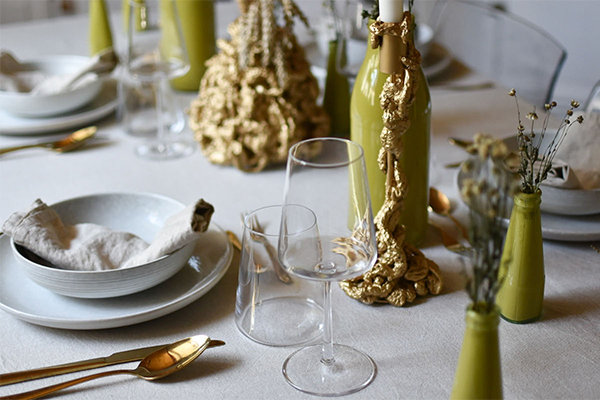 Gedeckter Tisch mit grünen Vasen und goldener Dekor