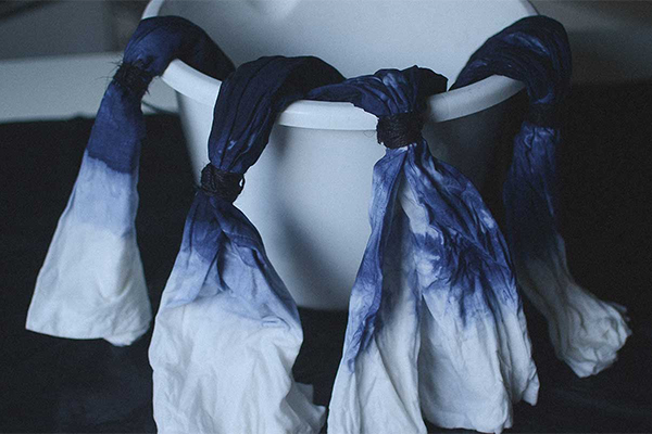 Soffe hängen aus einem Wäschekorb und sind zur Hälfte in blau und weiß gefärbt