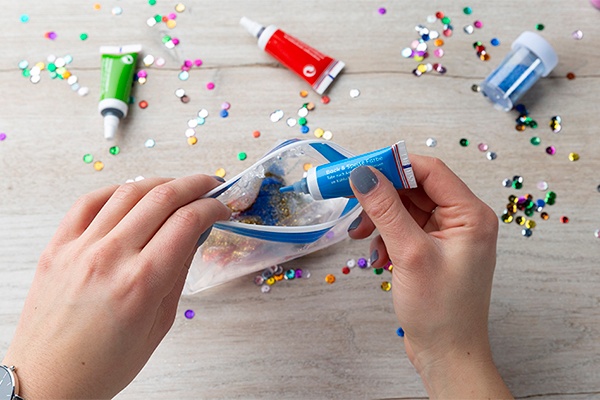 Glitzer und Lebensmittelfarbe in einen Gefrierbeutel füllen