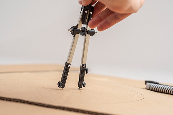 Piñata aus Karton und buntem Papier in Kreisformen ausschneiden, um eine zweistöckige Torte zu basteln