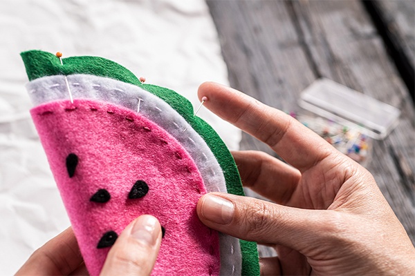 Das Etui auf die richtige Größe mithilfe von Nadeln zusammenstecken