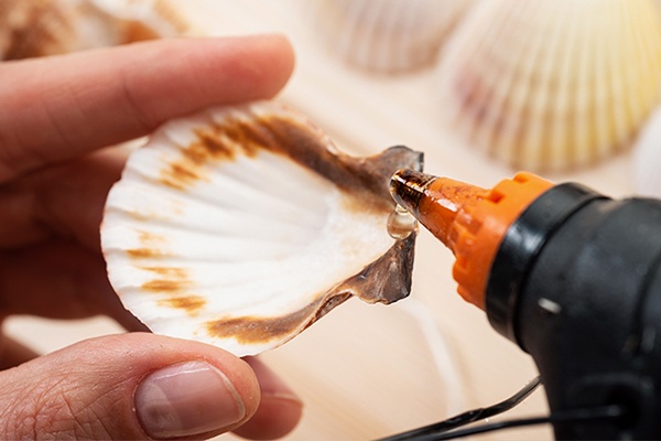 Muscheln am Rand mit Heißkleber verzieren