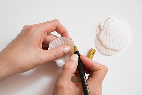Muscheln mit einem goldenen Stift umrahmen