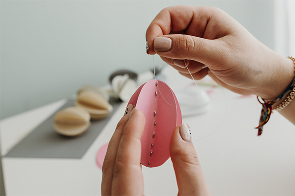 Faden wird an das Papier Ei angebracht