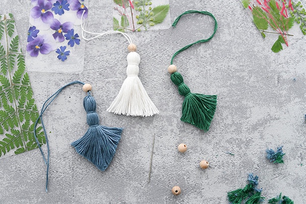 DIY Florale Lesezeichen aus Fransen, Holzkügelchen und gepressten Blüten sowie Blättern basteln