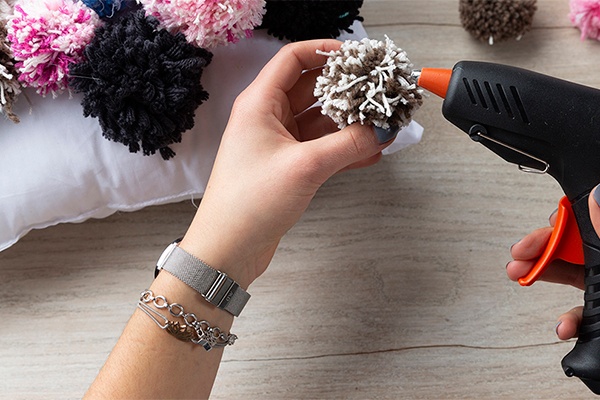 DIY-Polster mit Bommeln bekleben