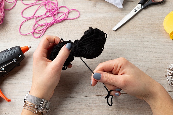 DIY-Polster mit Pompons aus einer Woll-Schnur
