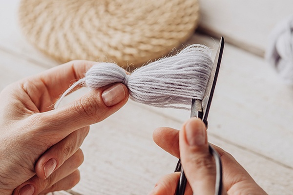 Quaste dekorativ an einem Ende aufschneiden, sodass sich Fransen ergeben