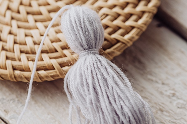 Die Wolle zusammenbinden und unten aufschneiden, damit sich schöne Fransen ergeben