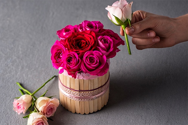 Blumen in die fertige DIY Flower Box stecken, in diesem Fall pinke und rote Rosen