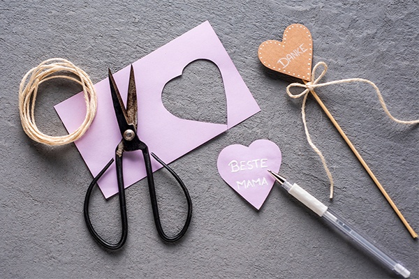 Als Deko für die DIY Flower Box kleine Herzschilder aus Papier schneiden und individuell beschriften