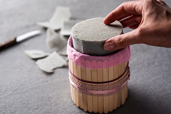 Zugeschnittenen Steckschwamm als Grundlage für die Blumen in die DIY Flower Box drücken