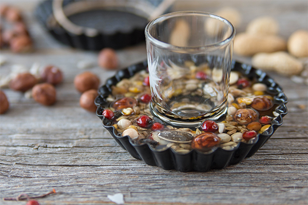 Herstellung eines Vogelfutterringes. In der Mitte ist ein Schnapsglas, sodass ein Loch entsteht.