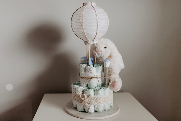 Windeltorte mit Heißluftballon und Kuscheltier verziert