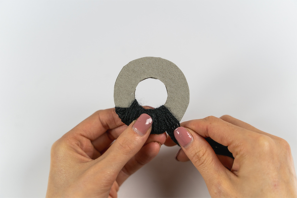 Um einen Kreis mit einem Loch wird eine Schnur gebunden