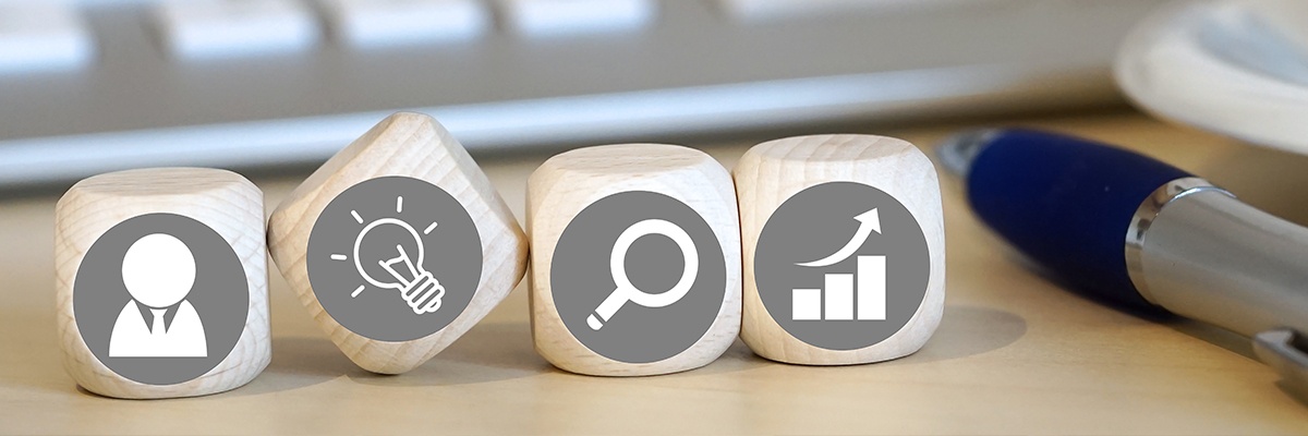 Foto zeigt vier Spielwürfel in einer Reihe mit Symbolen für Kompetenzen unserer Experten.