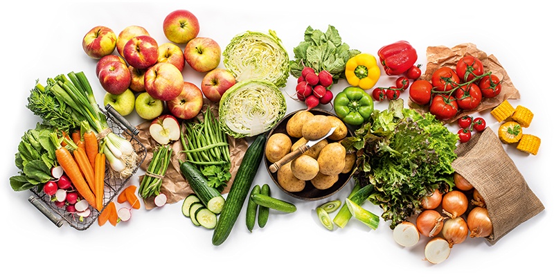 Verschiedene Gemüse- und Obstsorten auf einem weißen Hintergrund platziert.