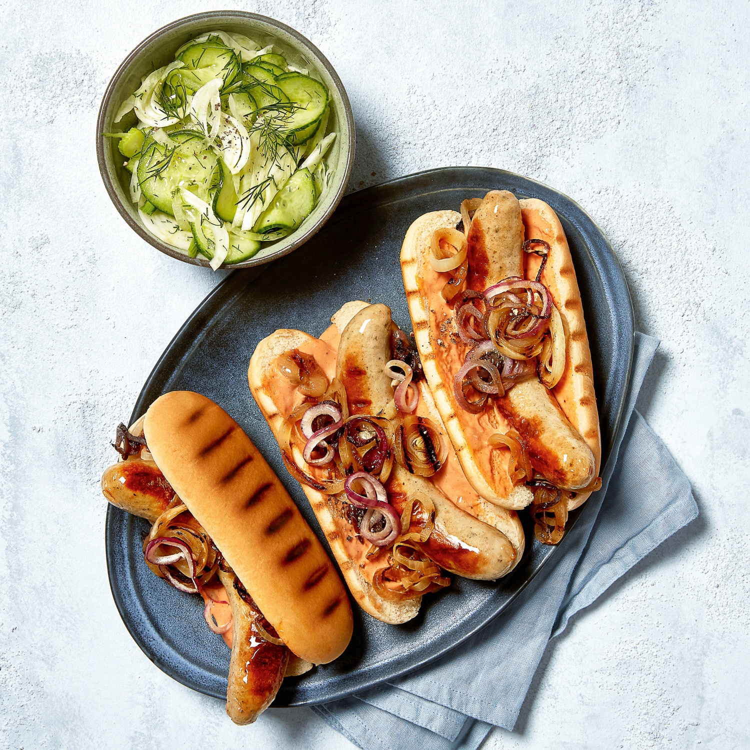 Hot Dog mit Bratwurst und frischem Gurkensalat