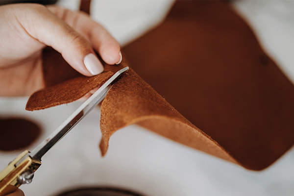 Brauner Filz wird mit einer Schere geschnitten