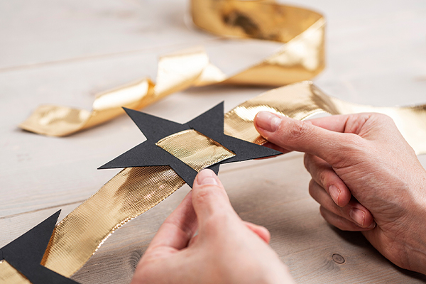 Schwarzer Papierstern und ein goldenes Band