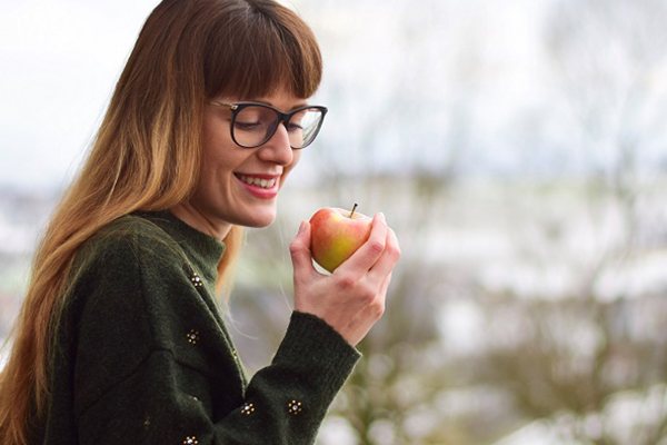 Frau hält Apfel in der Hand