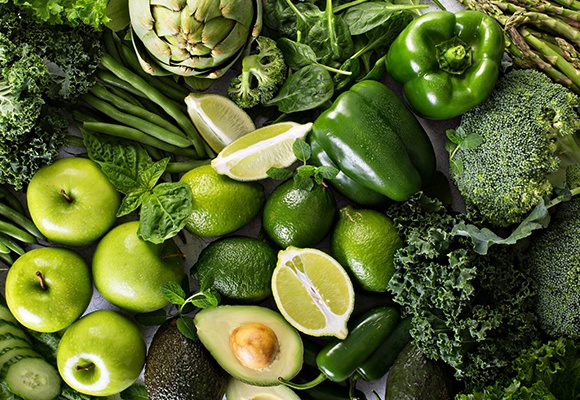 Grünes Gemüse und Obst wie Äpfel, Limetten, Bohnen, Kohl und Brokkoli 