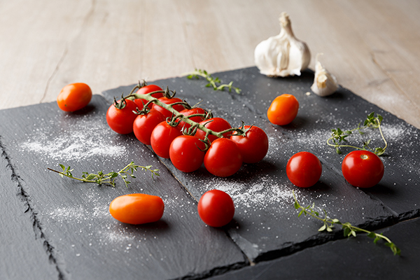 Cocktailtomaten auf einer Schieferplatte mit Knoblauch