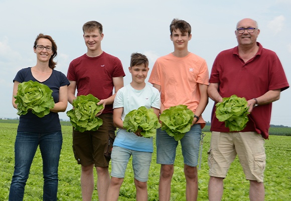 Familie steht im grünen Salatfeld
