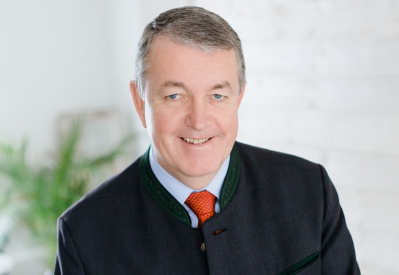 Älterer Mann im Anzug und roter Krawatte.