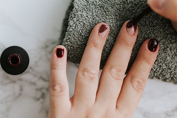 Nägel werden mit Topcoat lackiert