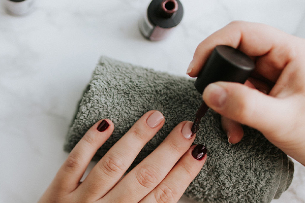 Nägel werden dunkelrot lackiert