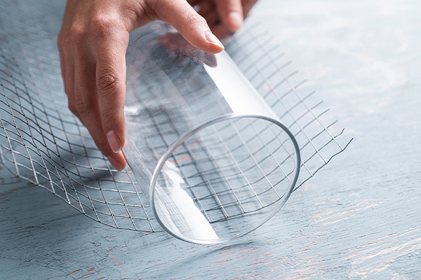 Maschendraht wird um ein Glas gelegt