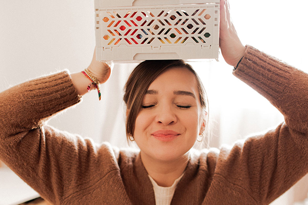 Frau hat eine Kiste auf dem Kopf